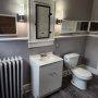 bathroom vanity sink and medicine cabinet with sconces and comode