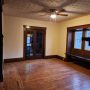 view into living room and front enclosed porch doors from West side dining room doorway