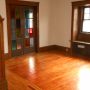 view into living room and front enclosed porch doors from West side dining room doorway