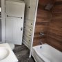 view of bathtub and shower and linen closet and drawers