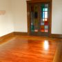 view of doors to front enclosed porch through living room from East side dining room doorway