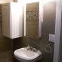 bathroom sink, medicine cabinet, light fixture, storage cupboard