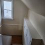 view down stairway to entry door , storage cabinets on right