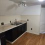 view into kitchen sink, counter and cabinet area from hallway doorway